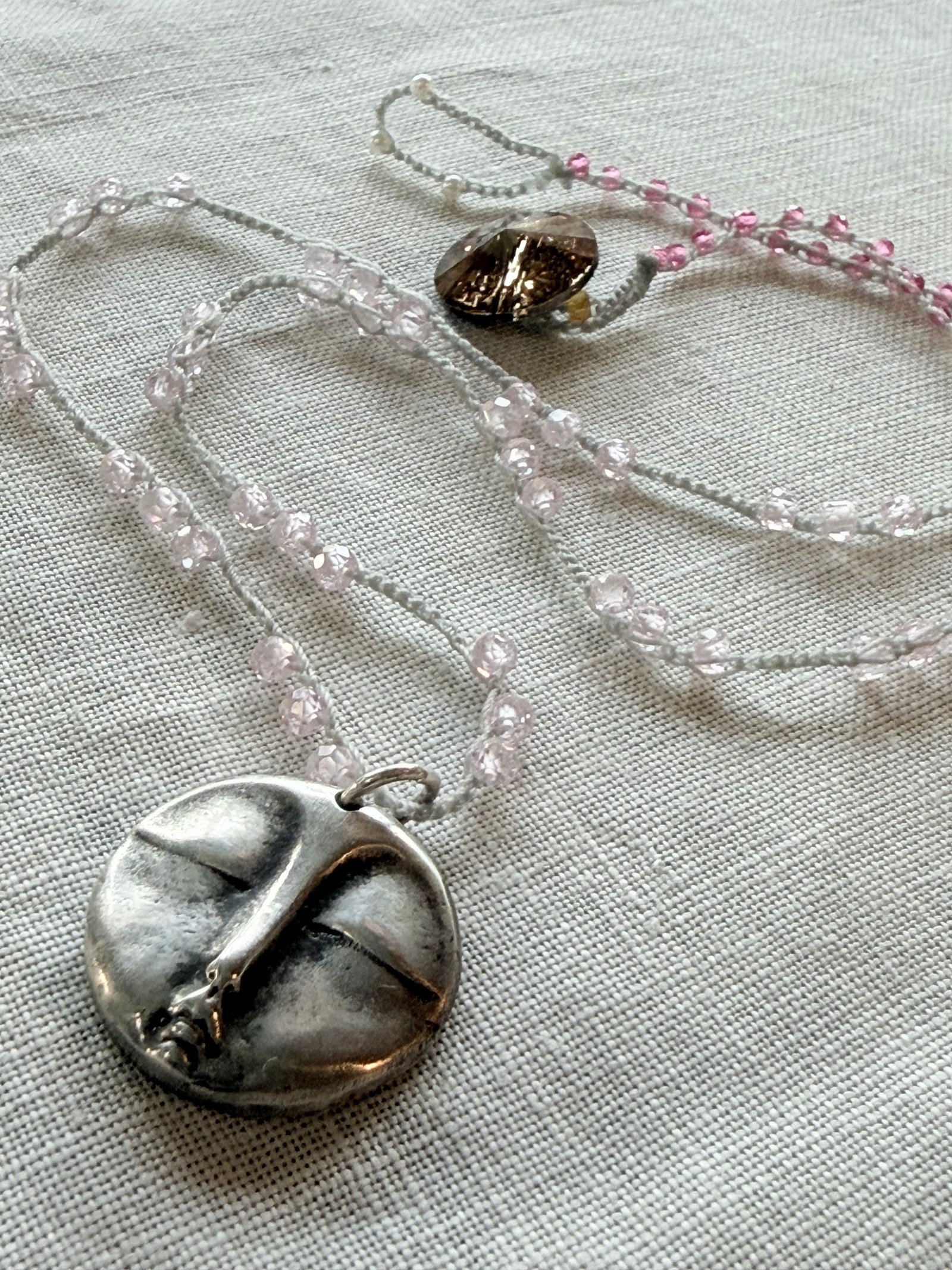 Blush gemstone crochet necklace with an antiqued botanical silver medallion